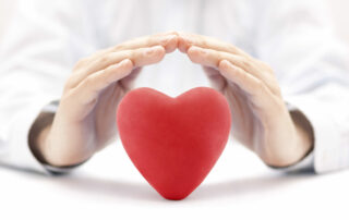 Red Heart Covered By Hands. Health Insurance Or Love Concept